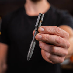 USA Bolt Action Pen in gray metal finish held by a person with a black shirt
